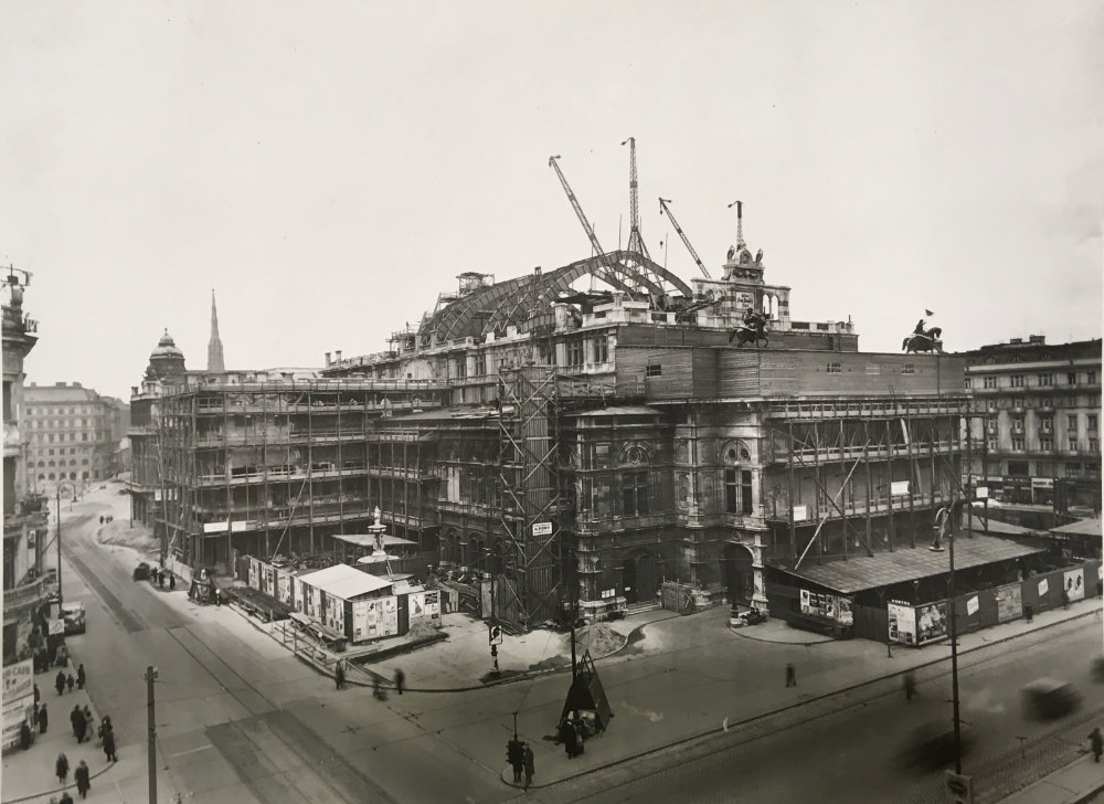 Dachneubau der Wiener Staatsoper - zu sehen ist die Fassade von links übereck mit dem neuen Dachstuhl und Kränen. Im Hintergrund die Spitze des Stephansdoms.